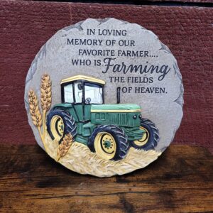 Stepping stone that says, "in loving memory of our favorite farmer....who s farming the fields of heaven"